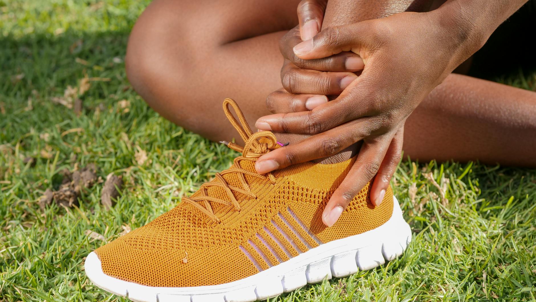 runner holding knee on park path, concern but not panic